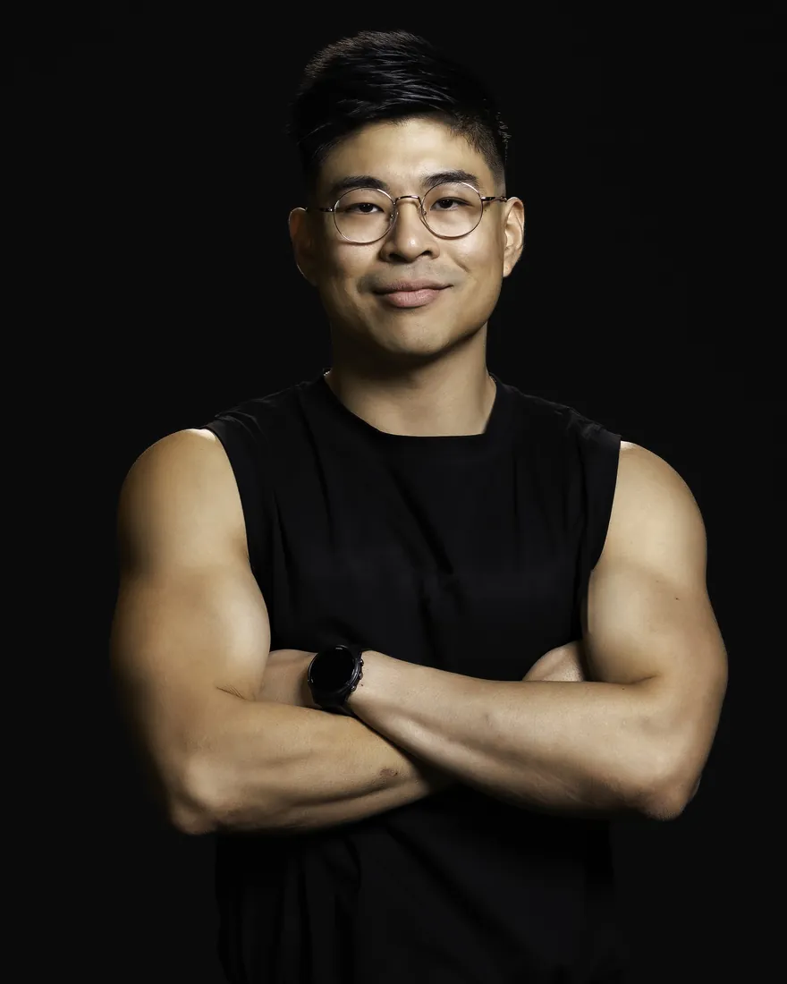 Winno, arms crossed, in a black training top